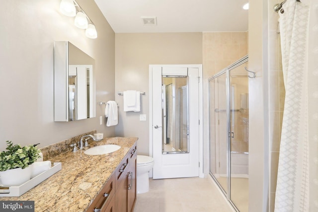 bathroom with toilet, a shower with door, vanity, and tile patterned floors