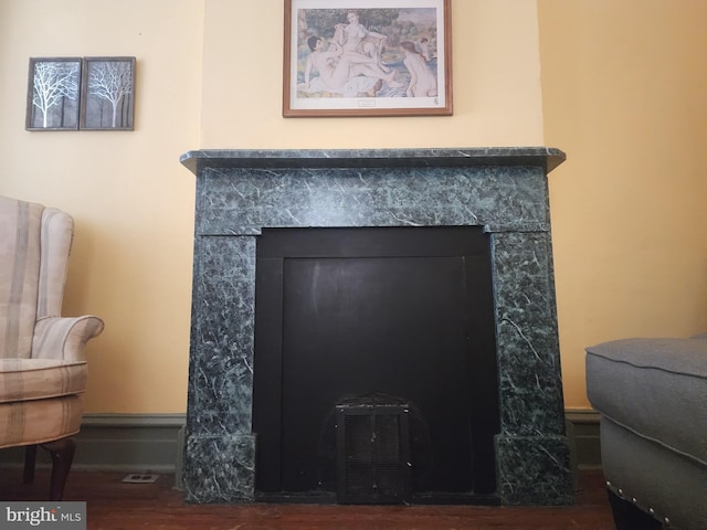 details with hardwood / wood-style flooring and a tile fireplace