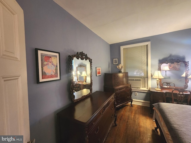 bedroom featuring dark hardwood / wood-style flooring, vaulted ceiling, and cooling unit