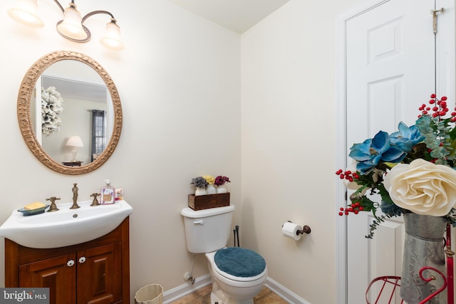 633 E Main St, Fruitland, MD 21826 - bathroom featuring toilet, baseboards, and vanity