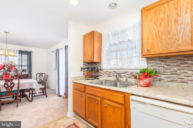 633 E Main St, Fruitland, MD 21826 - kitchen with white dishwasher, light carpet, a sink, hanging light fixtures, and decorative backsplash