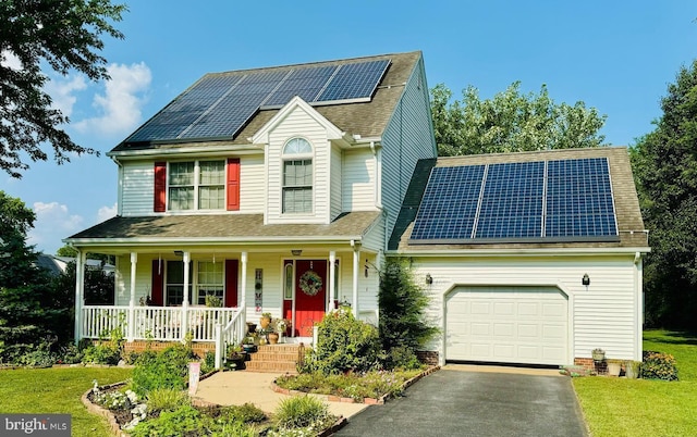 view of front of property with a shingled roof, solar panels, aphalt driveway, an attached garage, and covered porch