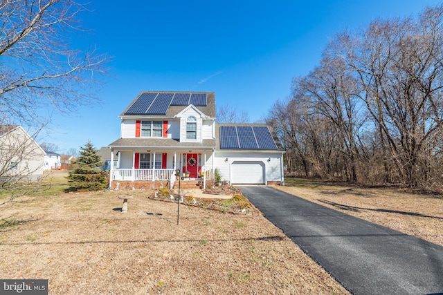633 E Main St, Fruitland, MD 21826 - view of front facade featuring solar panels, aphalt driveway, an attached garage, a porch, and a front yard