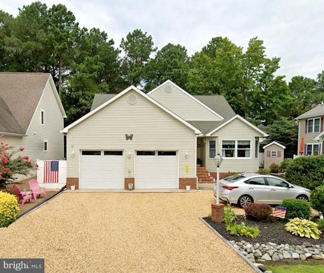 view of front of property featuring a garage and gravel driveway