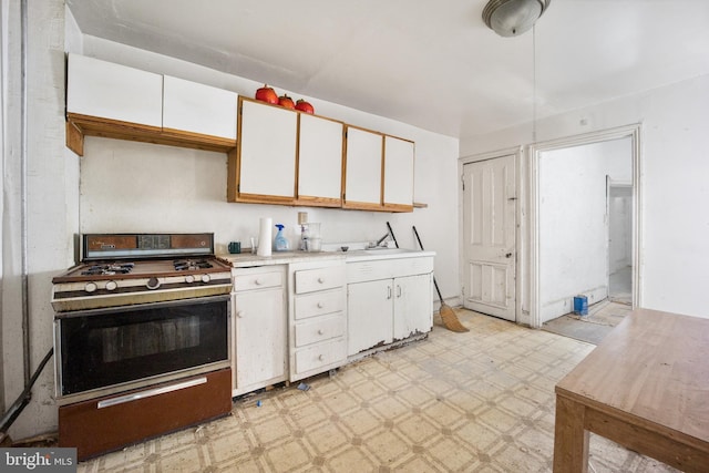 kitchen with white cabinets, range, and sink