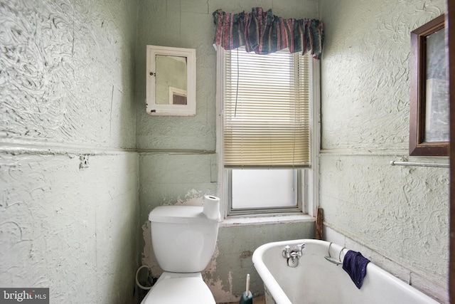 bathroom featuring a tub and toilet