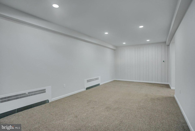 carpeted empty room featuring radiator heating unit