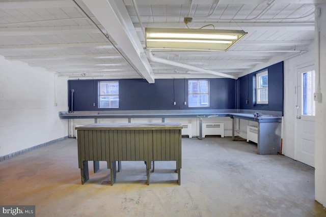 kitchen featuring white cabinets, beam ceiling, and radiator