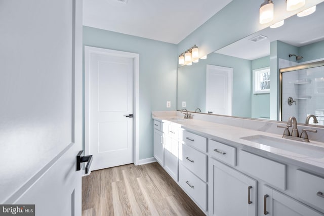 bathroom featuring wood-type flooring, walk in shower, and vanity