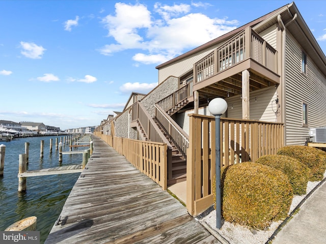 view of dock with a water view and central air condition unit