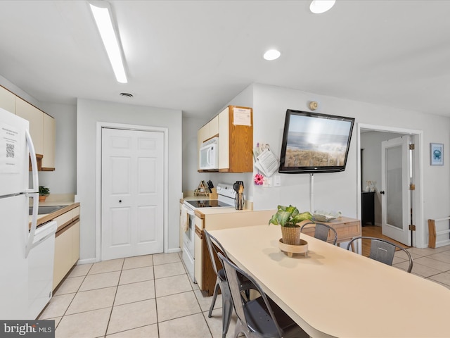 kitchen featuring light tile patterned floors and white appliances