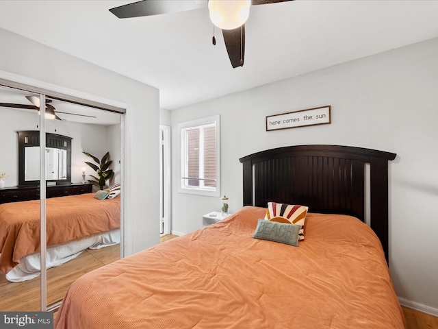 bedroom with a closet, light hardwood / wood-style flooring, and ceiling fan