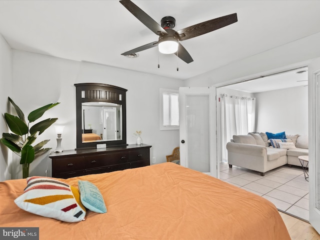 tiled bedroom featuring multiple windows and ceiling fan