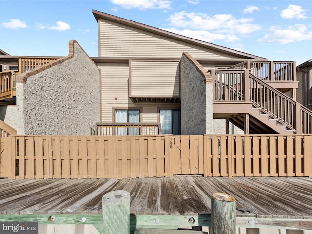 rear view of house featuring a wooden deck