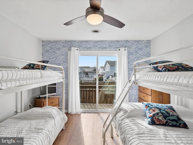 bedroom with hardwood / wood-style flooring, ceiling fan, and access to exterior