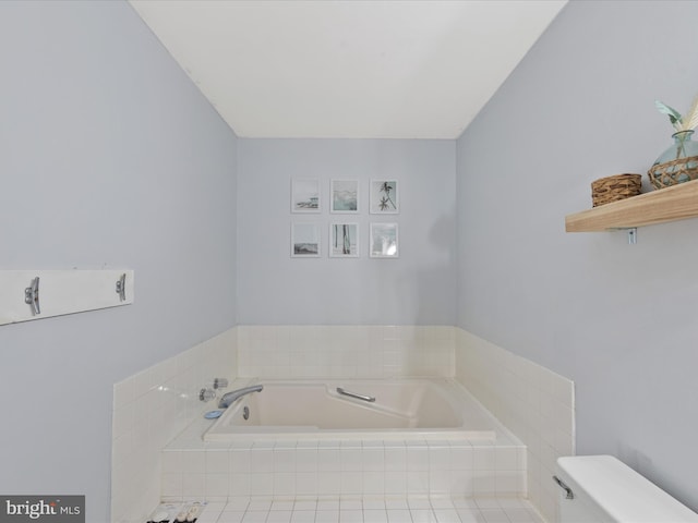 bathroom featuring tiled bath and toilet