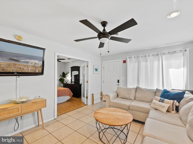 living room featuring ceiling fan, light tile patterned flooring, and a healthy amount of sunlight