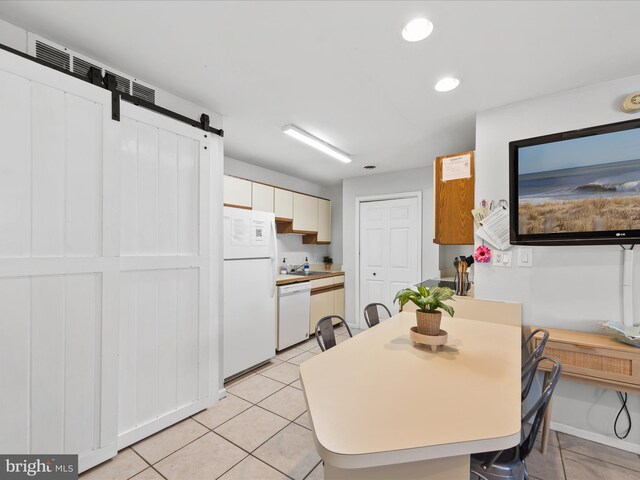 tiled dining area featuring a barn door