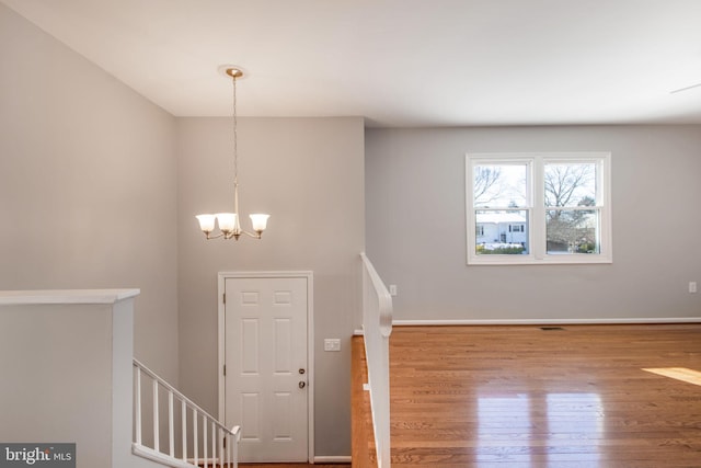 entryway with hardwood / wood-style flooring and an inviting chandelier