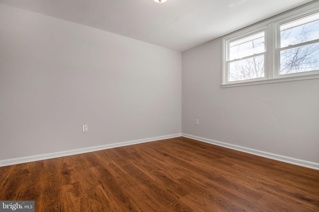 empty room with dark hardwood / wood-style flooring