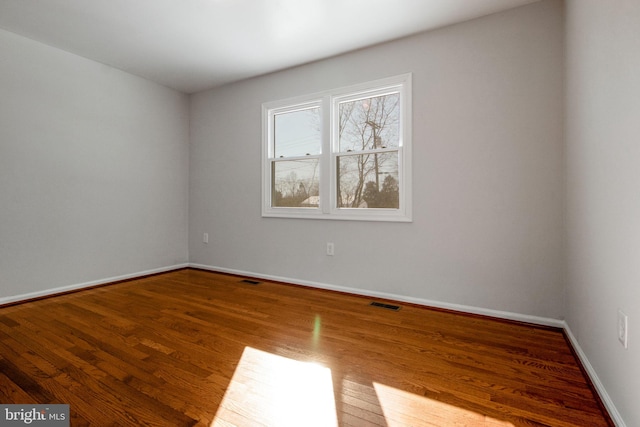 unfurnished room with hardwood / wood-style floors