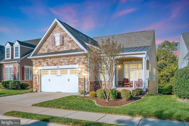 view of front of house featuring a garage, a porch, and a lawn