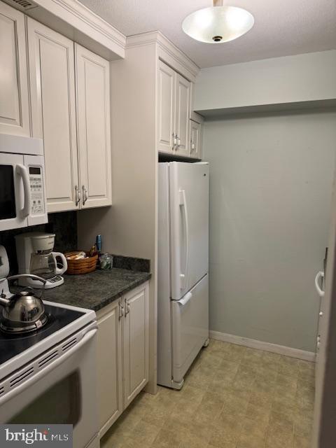 kitchen featuring white cabinetry, white appliances, and crown molding