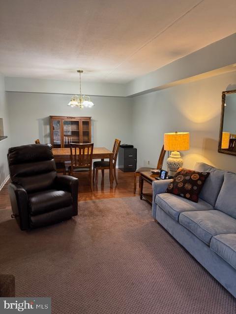 carpeted living room featuring an inviting chandelier