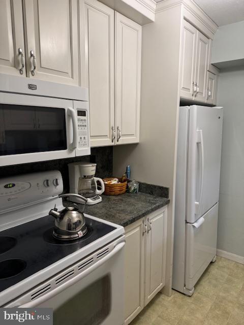 kitchen with white appliances and white cabinets