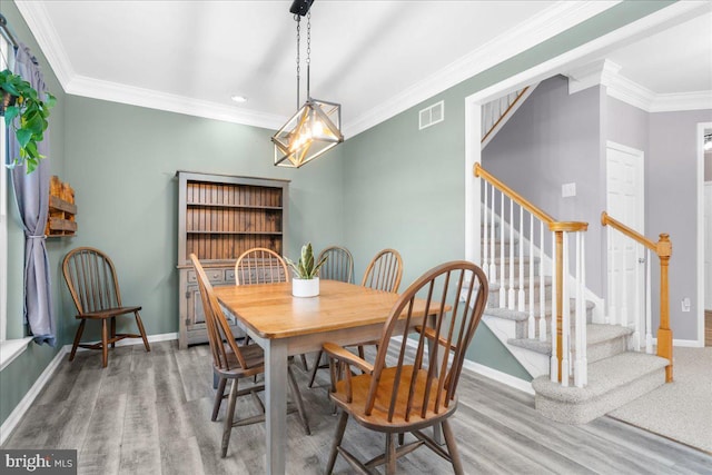 dining area featuring ornamental molding and hardwood / wood-style flooring