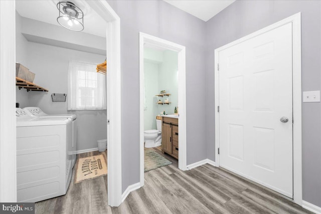 laundry room featuring washing machine and dryer and light hardwood / wood-style flooring