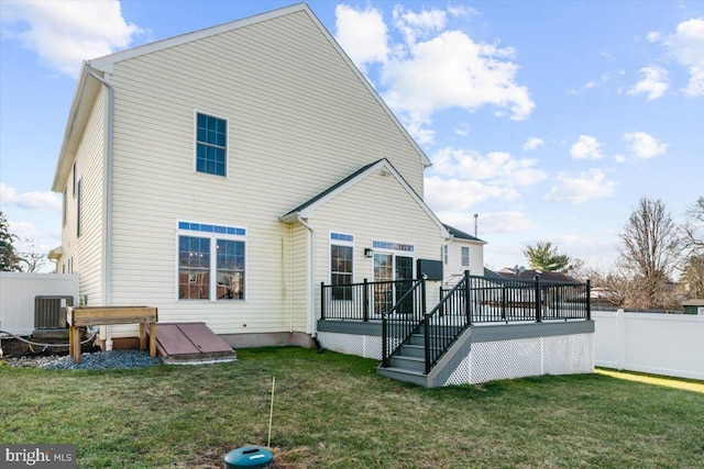 back of property featuring a lawn, central AC unit, and a deck