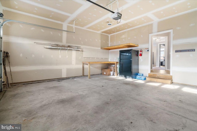 garage with black refrigerator and a garage door opener