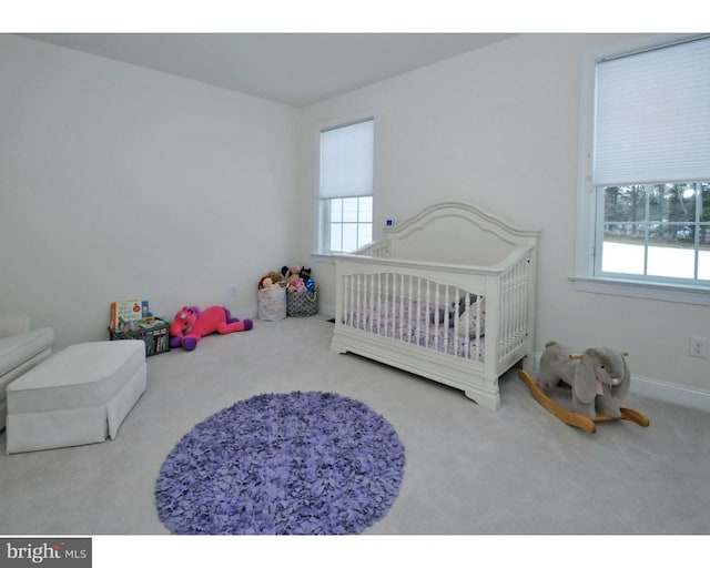 carpeted bedroom featuring a crib