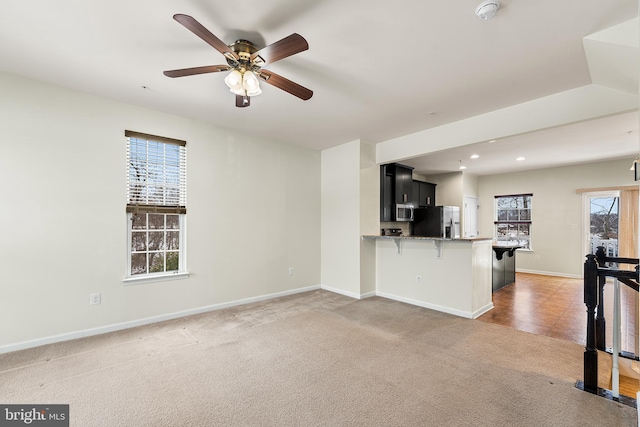 unfurnished living room with carpet flooring and ceiling fan