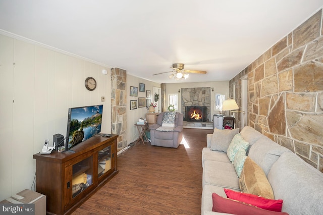 living room featuring ceiling fan, a fireplace, and dark hardwood / wood-style flooring