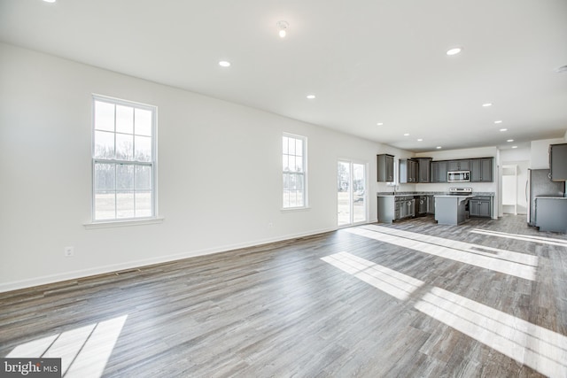 unfurnished living room with light wood-type flooring and sink