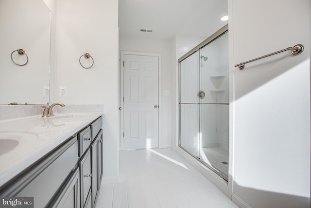 bathroom with tile patterned flooring, vanity, and an enclosed shower