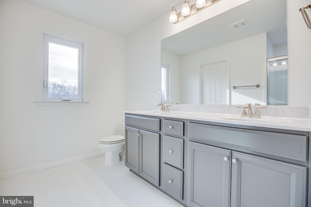 bathroom with vanity, toilet, and a shower with door