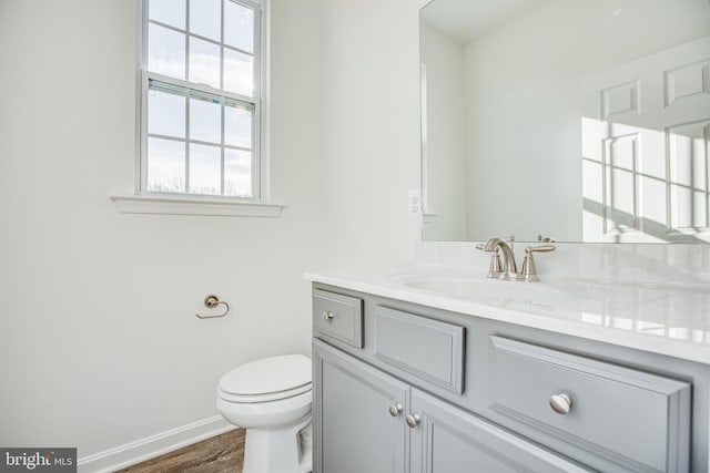 bathroom featuring wood-type flooring, vanity, and toilet