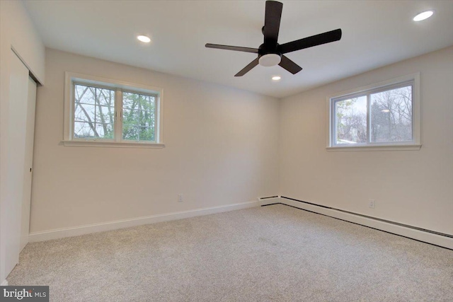 carpeted empty room featuring baseboard heating and ceiling fan