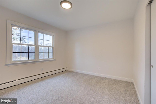 empty room featuring baseboard heating and light carpet