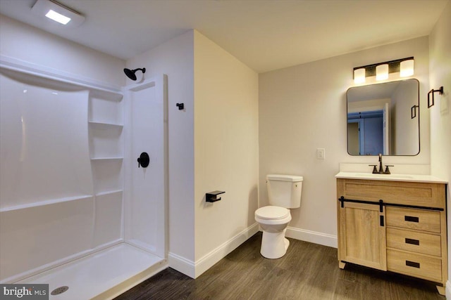 bathroom featuring hardwood / wood-style floors, vanity, toilet, and walk in shower