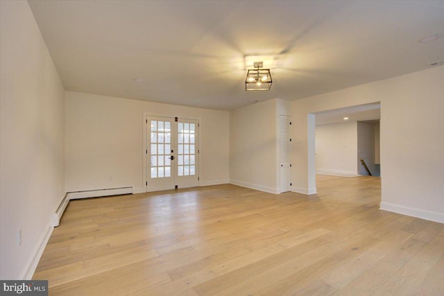 spare room with french doors, light hardwood / wood-style floors, and a baseboard radiator