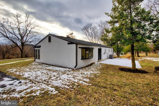 exterior space with a lawn and central AC unit