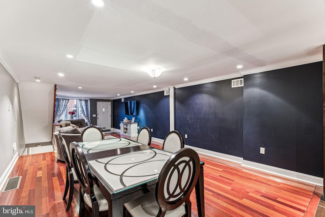 dining room with crown molding and hardwood / wood-style flooring