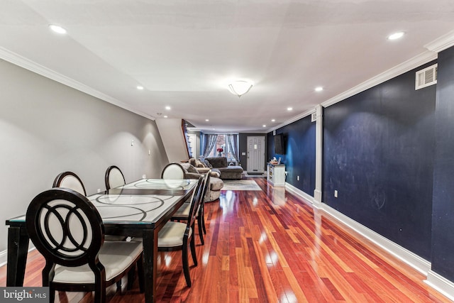 dining area featuring hardwood / wood-style flooring and crown molding