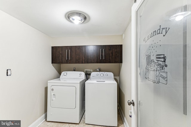 clothes washing area with cabinets and washing machine and dryer