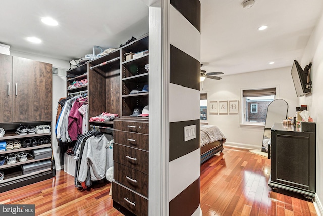 walk in closet with ceiling fan and light hardwood / wood-style floors