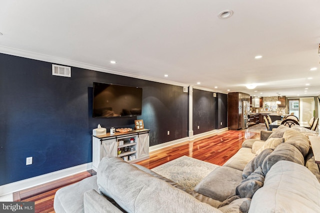 living room featuring crown molding and light hardwood / wood-style floors